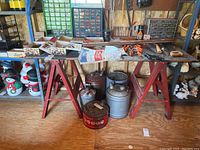 Wide view of the saw horse table with plywood top, showing content on table and surrounding area.