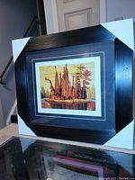 Framed fine art print by Lawren Harris shown with protective corner covers on black frame.