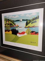 Close-up front view of the framed print showing the colorful landscape of Digby Inlet with houses, water, and a sailboat.