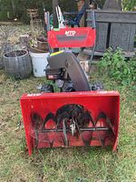 Front view showing red steel auger housing with black auger blades