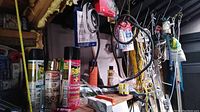 Image showing Raid and Krylon spray cans, rope, and assorted tools hanging behind