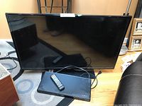 Samsung 39-inch TV and Philips DVD player together, shown with remote on DVD player