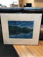 Framed limited edition watercolour print featuring landscape of hills and reflective water under clouded sky.