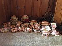 Full collection arranged on floor showing plates, cups, bowls, pitchers, tureen, compote and assorted serving pieces.