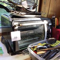 Bravetti convection oven with glass door and metal rack, black exterior, control knobs on side, with number tag.