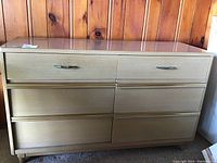 Front view of the wood veneer dresser showing six drawers and metal handles.