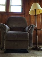 Frontal view of the grey La-Z-Boy power recliner chair next to the wooden floor table lamp.