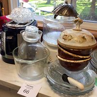 Photo showing two slice toaster, Black and Decker Handy Steamer, glass butter dish, glass pitcher with lid, glass bowl, four glass dishes, butter spreader, metal collapsible steamer, and three pottery bowls with dome lid.