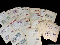 Overview photo of multiple first day covers arranged on pages, showing variety of stamps and envelopes.