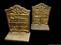 Pair of gold painted iron bookends embossed with bookshelf and Shakespeare quote shown on black background
