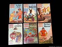 Six Classics Illustrated Junior comic books with colorful illustrated covers laid out in two rows. Titles include The Magic Pitcher, The Donkeys Tale, The Runaway Dumpling, The Pearl Princess, The Glass Mountain, and The Golden Fleece. Each cover displays unique story-related artwork in mid-century comic style.