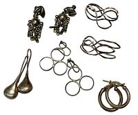 Photo showing five pairs of sterling silver earrings in various styles arranged on a white background