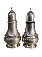 Pair of two solid sterling silver salt and pepper shakers, shown against a white background demonstrating classic antique design and condition.