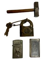 Photo showing jewelers hammer, Yale padlock with keys on chain, and two decorative metal lighters with engravings placed on white background.