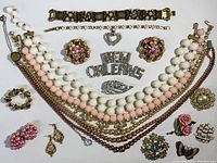 Full lot display of 19 vintage costume jewelry pieces including bracelets, necklaces, brooches, earrings, and pins