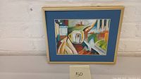 Full view of framed abstract expressionist pastel drawing with blue matte and beige frame.