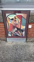 Framed Alexander Archipenko Centennial Tribute poster showing colorful cubist style artwork with geometric shapes representing a seated female figure.