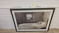 Framed Andrew Wyeth poster hung against brick wall, showing full image with dog on bed scene.