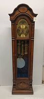 Full front view of tall case clock showing overall design and components