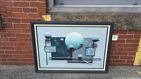 Full view of the framed abstract celestial oil painting with spheres and geometric shapes against a blue-toned background.