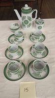 Full tea set with teapot, cups, saucers, creamer, and sugar bowl arranged on table showing green and white Fitzhugh pattern.