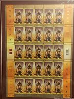 Front view of framed uncut stamp sheet showing 25 identical stamps with Year of the Dog 2006 design on yellow-orange gradient background