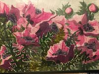 Close-up view of the watercolor painting showing pink flowers with detailed black and white centers and green leaves.