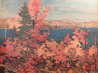 Close-up of framed artwork showing autumn landscape of trees, lake and mountains in warm colors with detailed brush strokes.