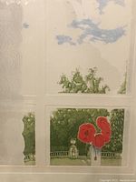 Close-up photo showing part of engraving with red flowers, greenery, and sky visible through pane-like grid in the image.