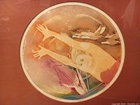 Close-up of the circular etching depicting a flying woman with birds, showing warm colors and pencil signature.