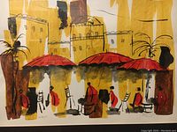 Full view of the painting showing the entire artwork with buildings, red umbrellas, and figures in cafe setting.