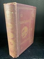 Front cover and spine showing red cloth with gilt tooling and wear on spine and edges