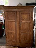 Front view of two-door pine armoire with recessed panels and base plinth