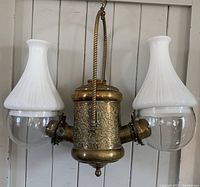 Front view of brass chandelier with two opaline and clear glass shades