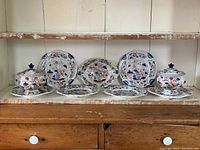 Overview showing two covered footed tureens, one open footed bowl and scalloped plates