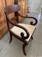 Full view of antique wooden armchair showing frame, arms and seat upholstery