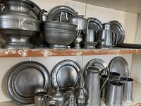 Top shelf view showing lidded tureen, nested bowls, small pot, pitchers and assorted plates