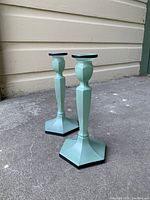 Full view of both Victorian-style candlesticks showing matte green glass finish and hexagonal base.
