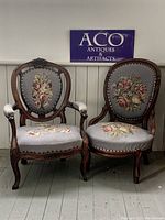 Pair of antique wooden parlour chairs with blue needlepoint upholstery, one with arms and one without, against a white background with ACO sign.