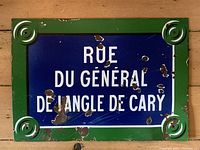 Front of the street sign showing the blue and green enamel with white text 'Rue du Général de Langle de Cary'. Visible chipping and wear on the enamel surface.