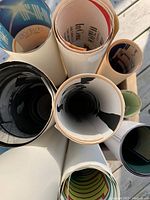 Top-down view of multiple rolled posters with visible colorful artwork and text on edges.