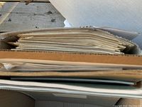 View inside box showing stacks of archival documents including musical scores and scripts