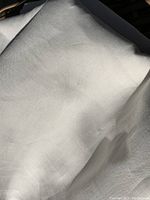 Folded large piece of natural linen fabric showing fine weave and texture under natural light.