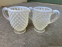 Photo of the vintage Fenton moonstone opalescent hobnail glass cream and sugar set showing the hobnail texture and milky glass appearance.