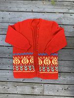 Full front view of vintage red knit Christmas sweater with button-up front and turtledove pattern near hem