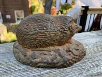 Side view of cast iron hedgehog door stop showing textured details and shape.