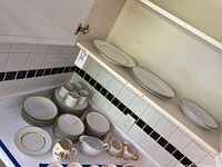Wide shot of the entire china and plate set including stacked plates, cups, saucers, and creamers