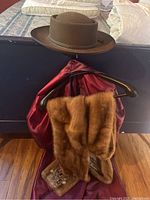 Both items displayed together: hat sitting atop shawl draped on hanger