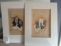 Two framed Japanese prints shown side by side with white border mats, detailed Kabuki dancers in traditional costumes, measuring approximately 18x24 inches each.
