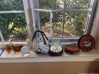 Overview of lot showing two amber glass animal figures, clear bubble-filled paperweight, Murano glass purse, crystal flower on wooden base, and additional wooden bases.